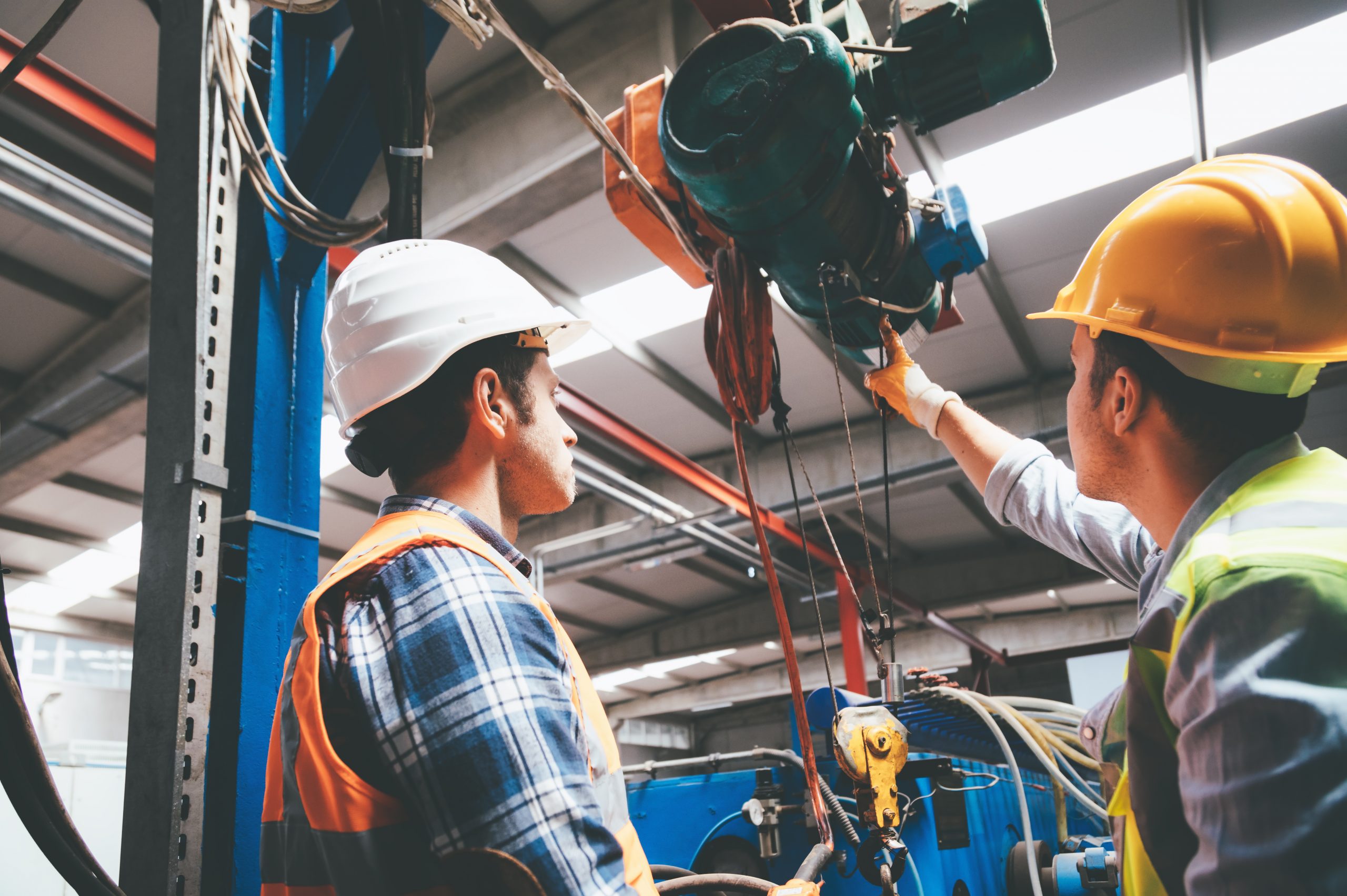 Industrial machinery male employees working with remote control for operating crane