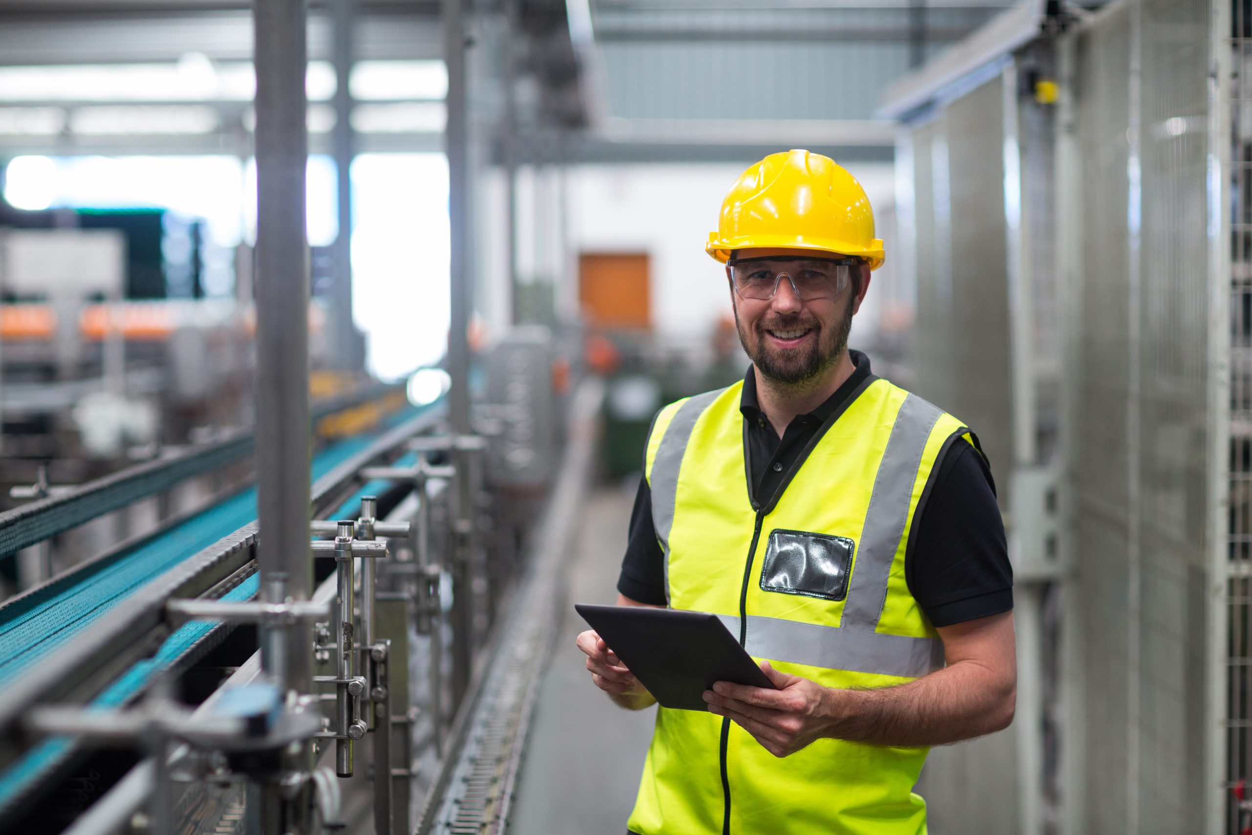 Portrait of smiling factory worker using a digital tablet